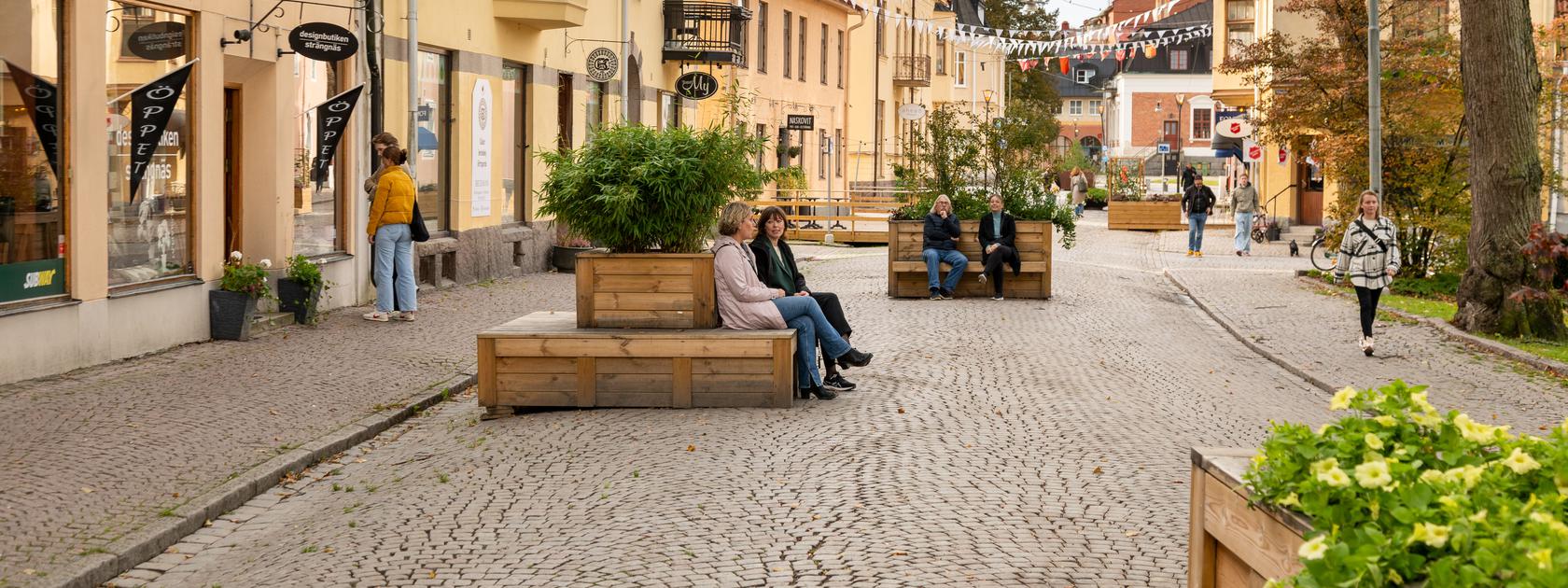 Personer i bild på sommargata i Strängnäs