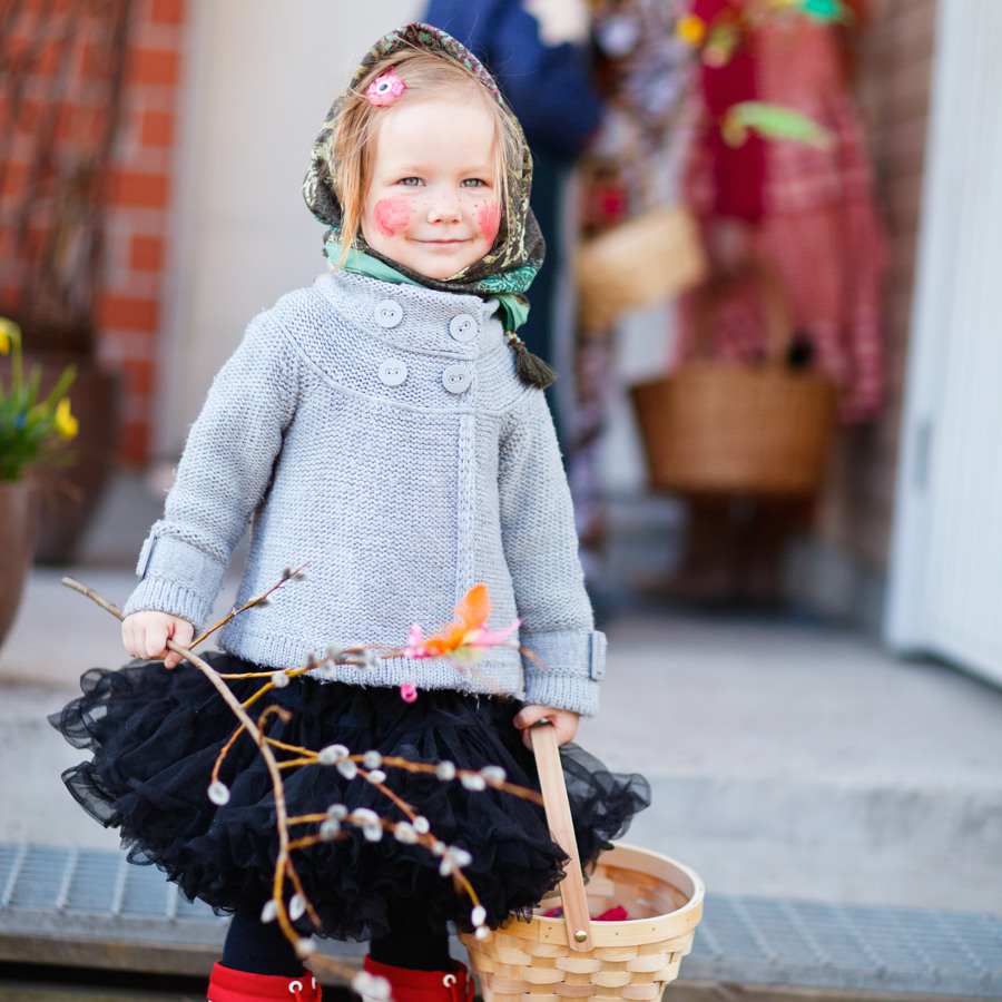 Adorable little girl outdoors collecting chocolate eggs as part of Easter tradition in Finland