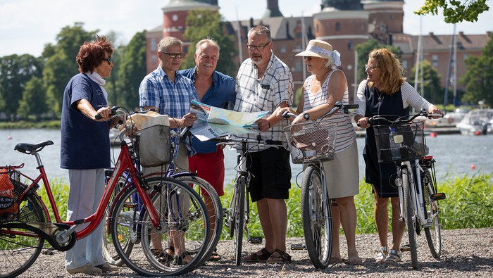 Cyklister titta på karta framför Gripsholms slott