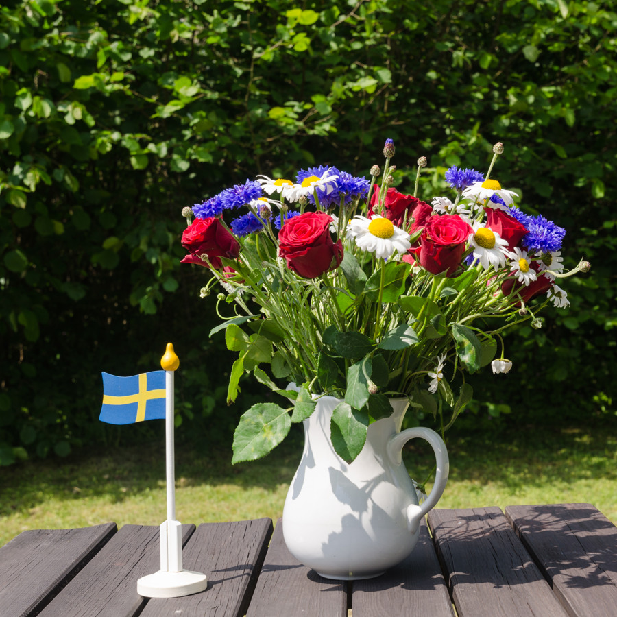 Bukett sommarblommor på ett bord i trädgården