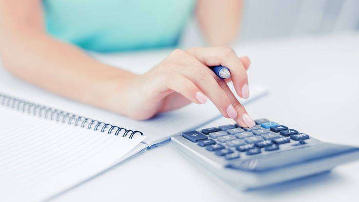 business concept - businesswoman working with calculator in office