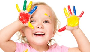 Portrait of a cute little girl showing her hands painted in bright colors, isolated over white
